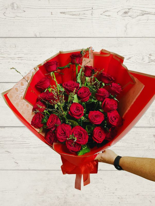 24 red roses with foliage wrapped in red and pink flowers.