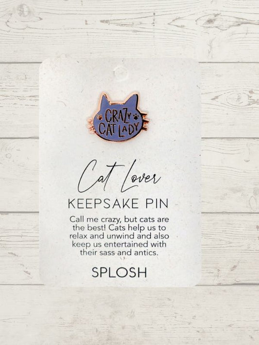 A keepsake pin with a rose gold ceramic pin badge that says 'Call me crazy but cats are great stress relievers. They relax and unwind me too.