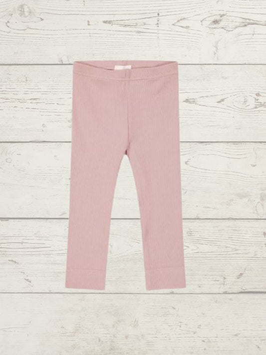 a pink pair of girls leggings on a wooden surface
