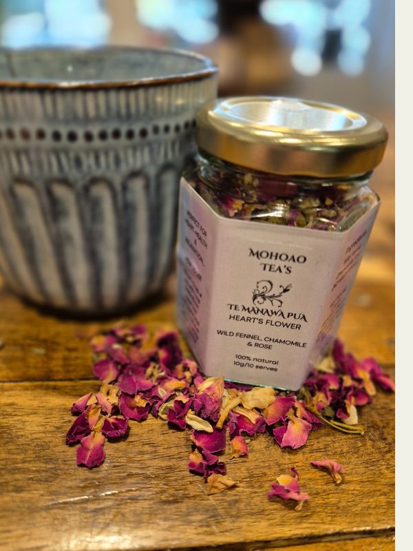 Jar of Mohoao Teas tea with dried flowers on a wooden surface