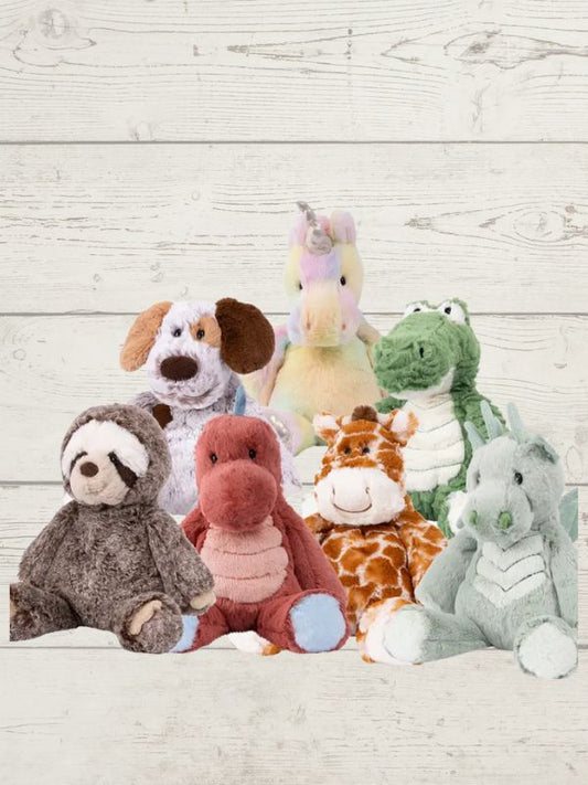 a collection of soft toys displayed on a white wooden background