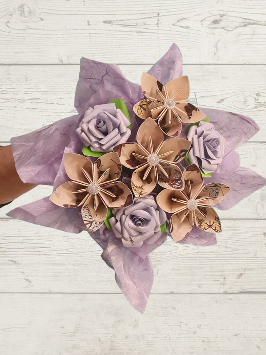 Bouquet of paper flowers in brown and purple on a wooden background