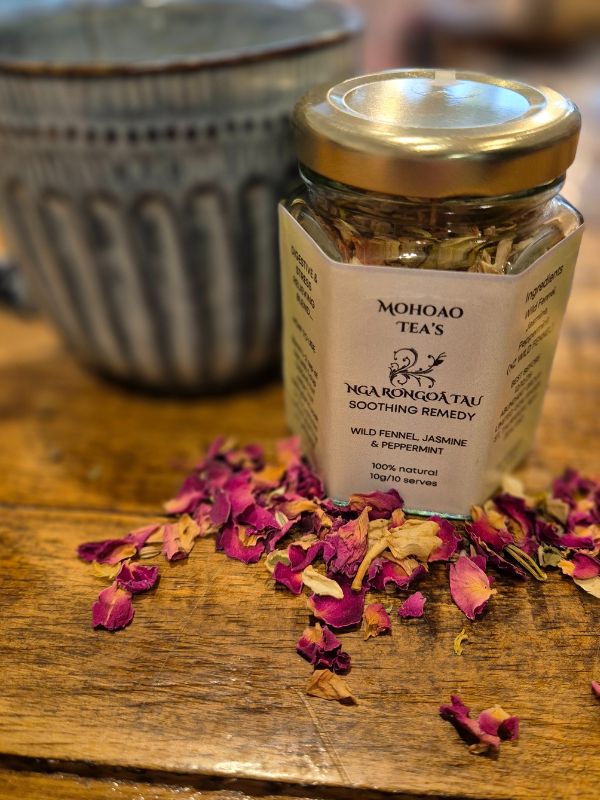 Jar of Mohoao Tea's Nga Rongoatu on a wooden surface with dried flowers.