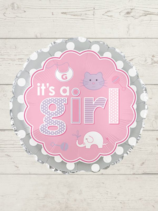 round pink and grey balloon with it's a girl written on it against a white wooden background.