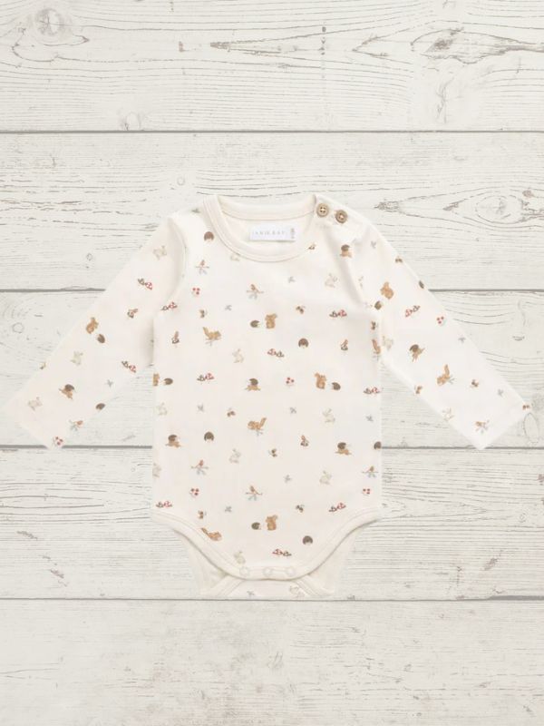 Baby bodysuit with animal prints on a light wooden surface