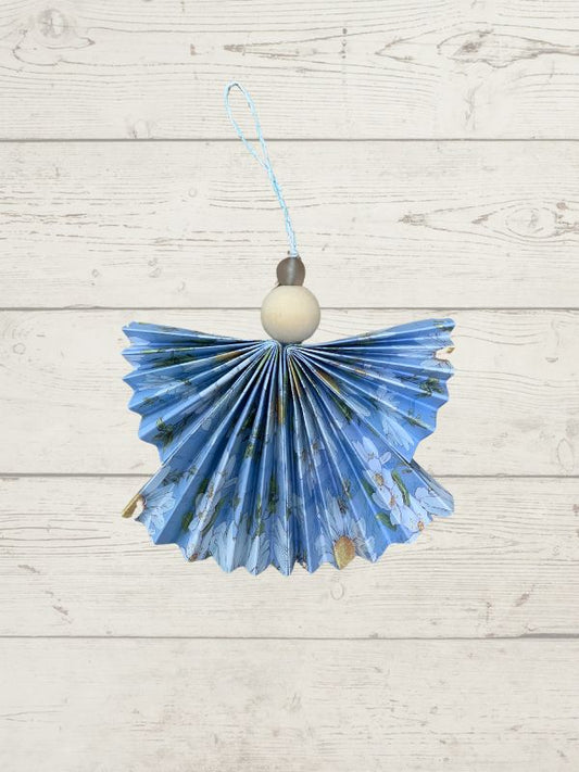 floral decoration, angel shaped with a wooden bead on a wooden surface