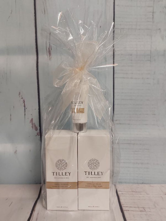 Tilley gift pack containing a body lotion, body wash and hand cream, gift wrapped on a white wooden background
