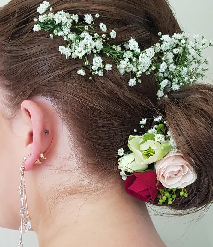 Woman's hair styled with flowers and a close-up of an earring.