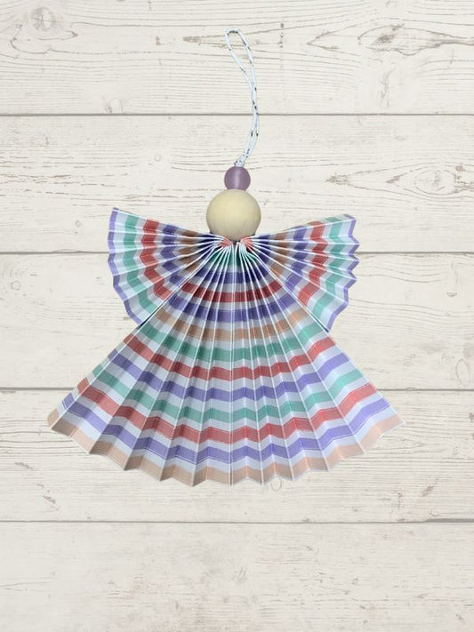 Decorative angel with striped wings on a wooden surface