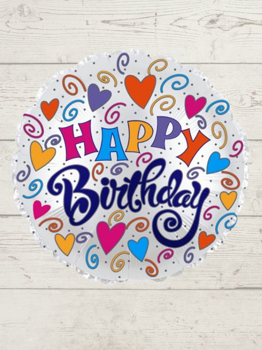 A round balloon with a 'Happy Birthday' message, decorated with colorful hearts and stars on a wooden background.