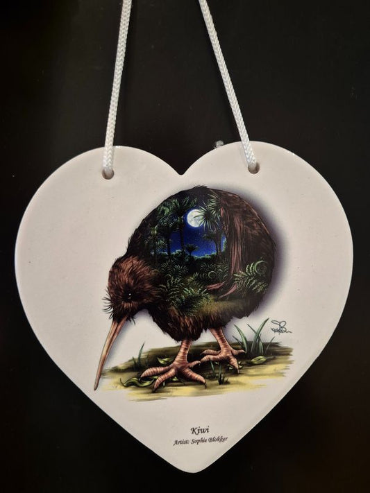 A ceramic heart-shaped plaque with a kiwi bird predominantly in shades of brown and blues, with a moon and stars background.