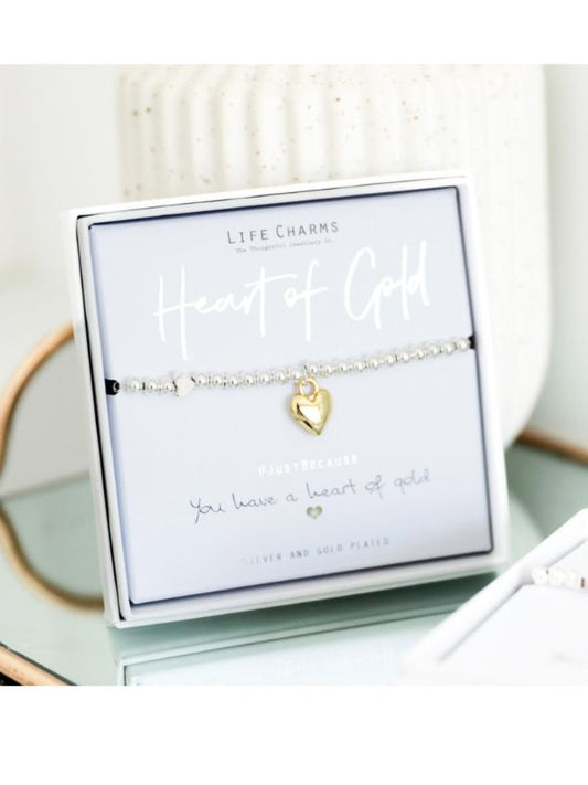 Gold heart bracelet in a 'Life Charms' packaging on a white surface