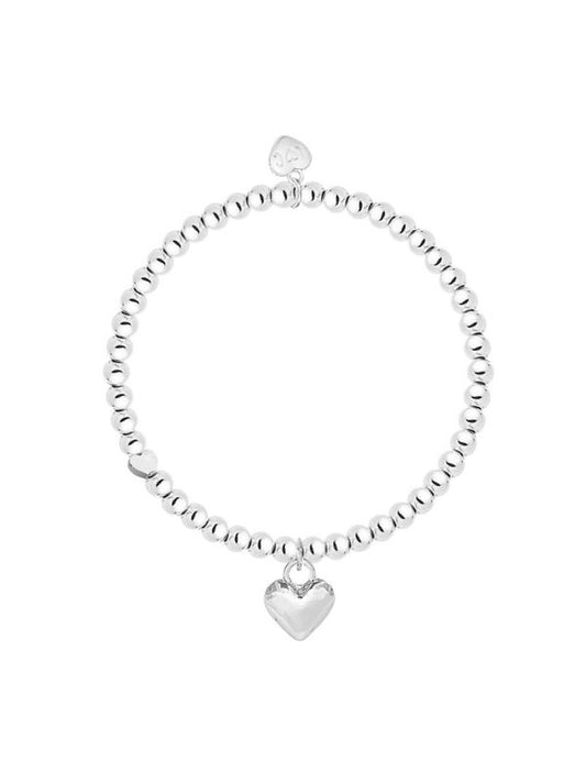 Silver bracelet with a heart charm on a white background