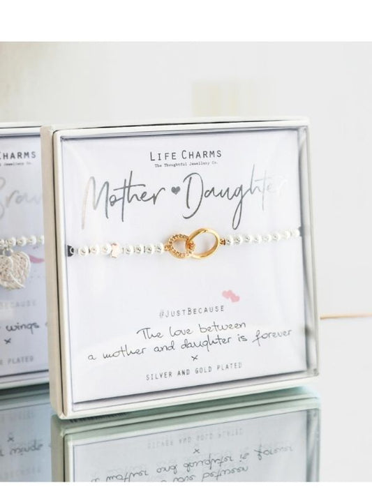 Bracelet set with 'Mother Daughter' card on a reflective surface