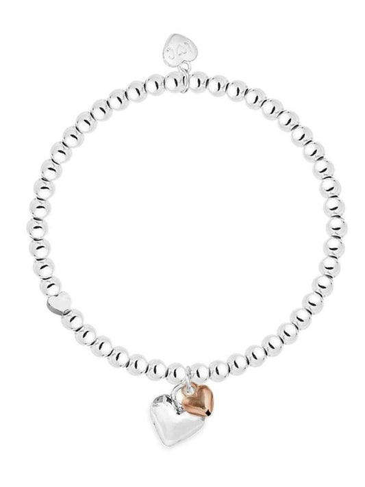 Silver bracelet with a heart-shaped charm on a white background