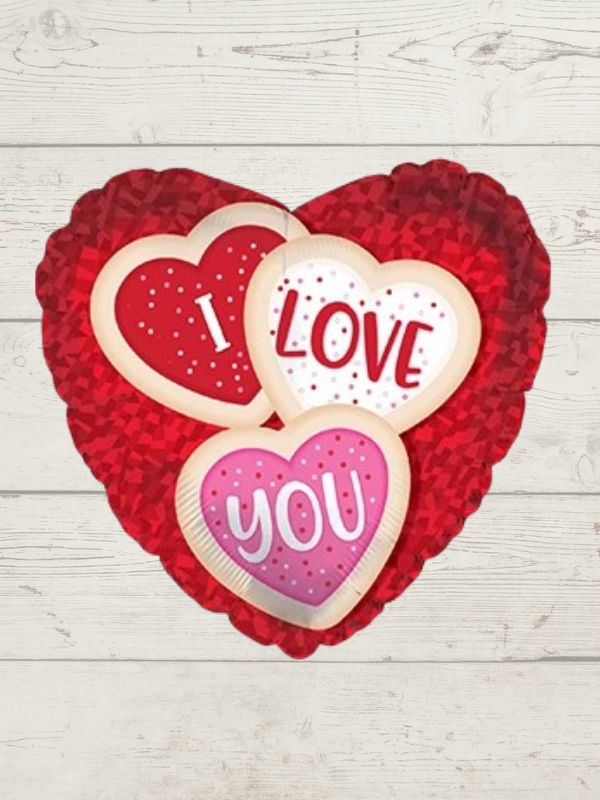 A balloon with a heart-shaped design containing the words 'I love you' and 'You' on a wooden background.
