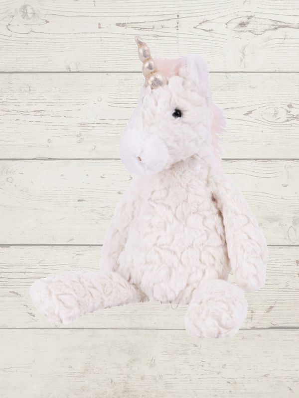 Plush unicorn soft toy on a light wooden background
