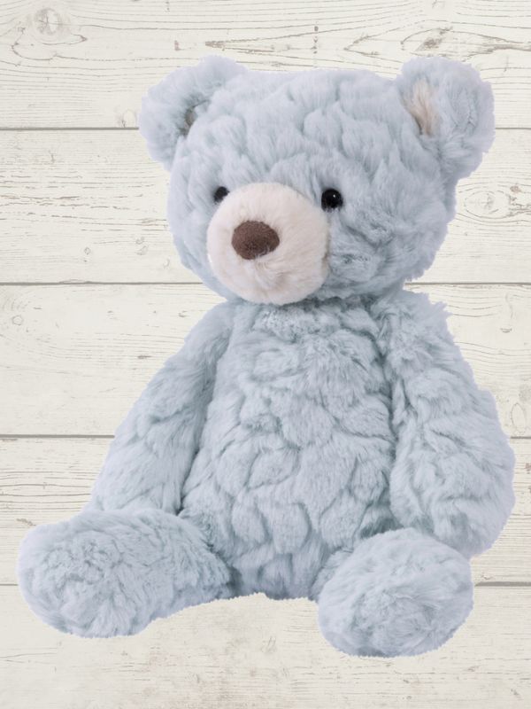 Blue teddy bear on a light wooden floor