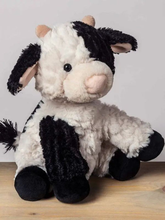 A plush toy resembling a cow with black and white fur, featuring embroidered eyes and a soft texture.