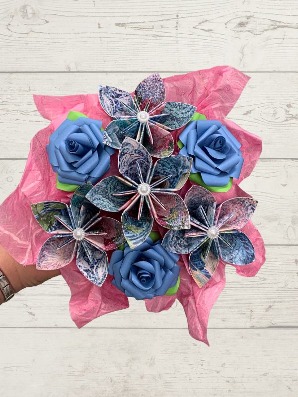 Bouquet of blue and pink artificial flowers on a wooden surface