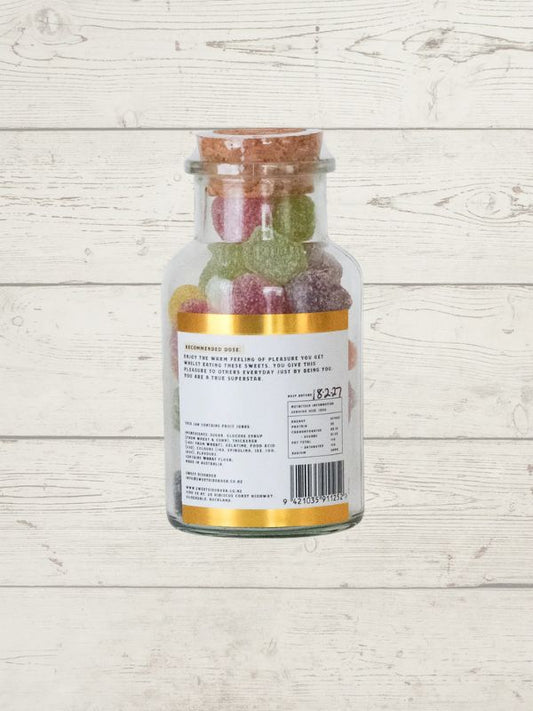 Jar of fruit gummies on a wooden surface
