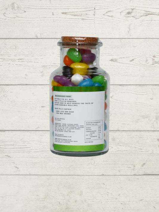 Bottle of colorful jelly beans on a light wooden surface