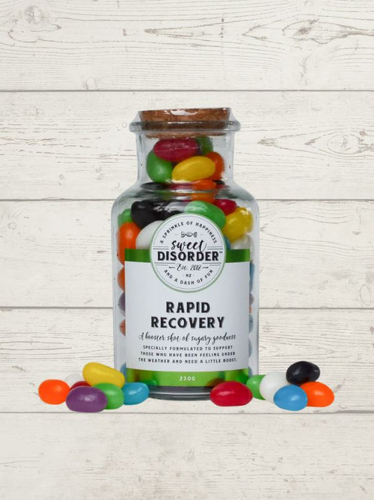 Jar of jelly beans with a label reading 'Sweet Disorder' on a wooden surface.