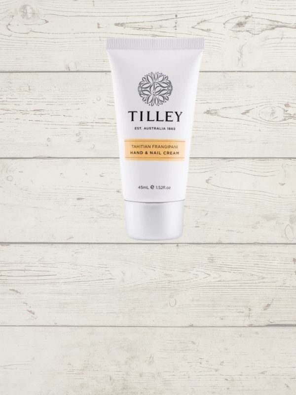 A tube of Tilley Hand Cream with a white and orange label, 45mls, displayed against a wooden background.