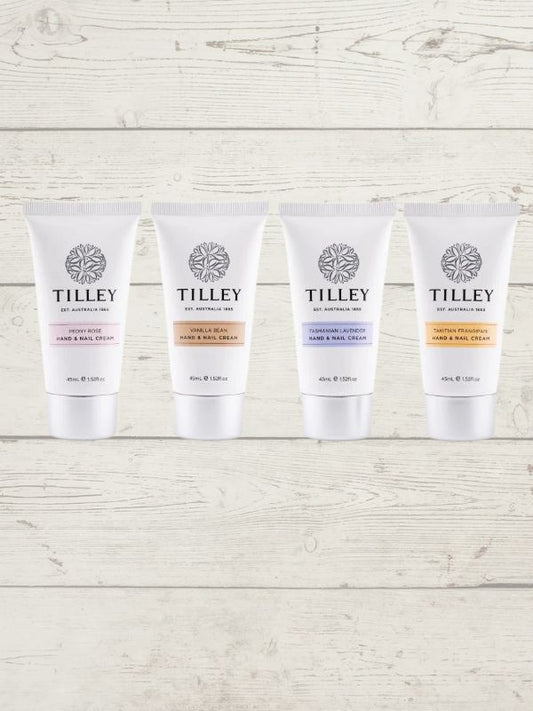 Four tubes of Tilley Hand Cream in different shades, displayed upright on a wooden surface.