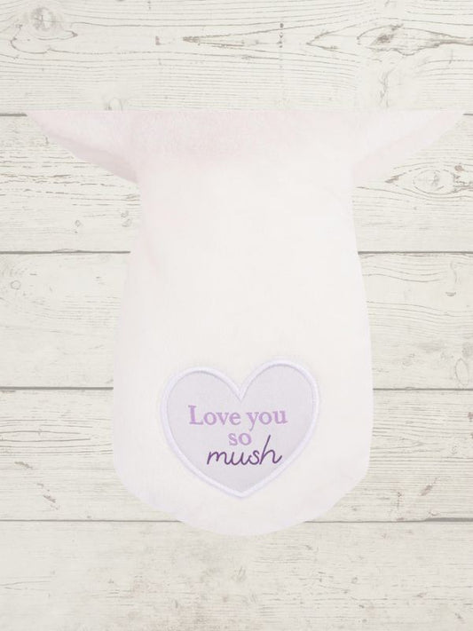 Heart-shaped sticker with 'Love you so mush' text on a wooden surface
