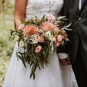 Bride and groom with a bouquet of flowers in a natural setting