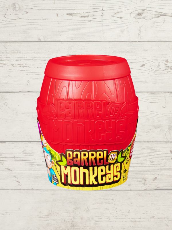 a red barrel with the words 'Barrel of Monkeys' with some cartoon monkeys on it on a wooden background