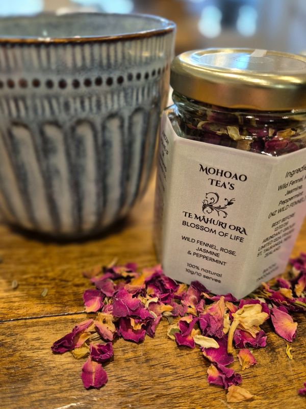 Jar of dried flowers from Mohoao Teas on a wooden surface with a blurred background