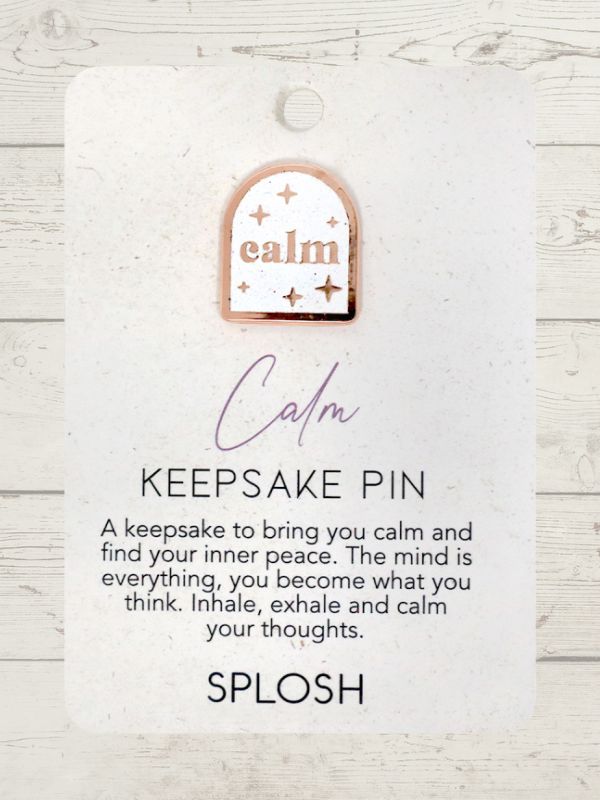 A keepsake pin with the word 'Calm' written on it, along with some inspirational quotes, attached to a white card with the brand name 'Splosh'.