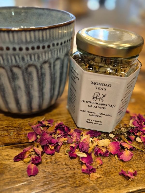 Jar of Mohao Teas tea with dried flowers on a wooden surface