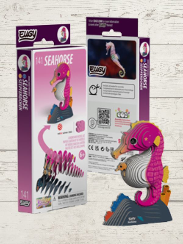 Pink and purple seahorse toy with packaging on a light wooden surface