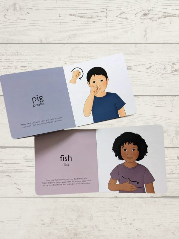 2 opened books with kids showing sign language with the words in and Fish on a wooden background