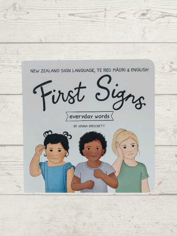 Cover of the book 'First Signs - Everday words 2' featuring illustrations of three diverse children making sign language gestures, with the title and author's name 'Anna Brockett' displayed.