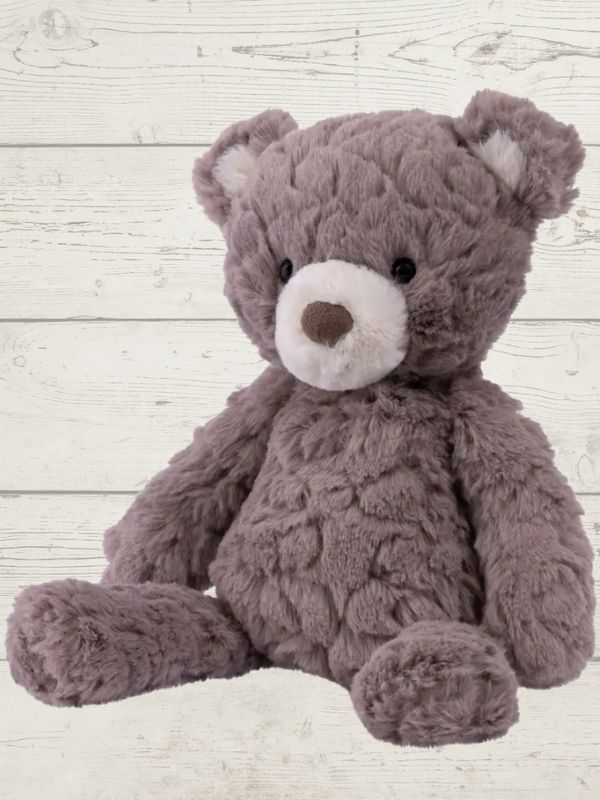 grey bear sitting on a wooden surface