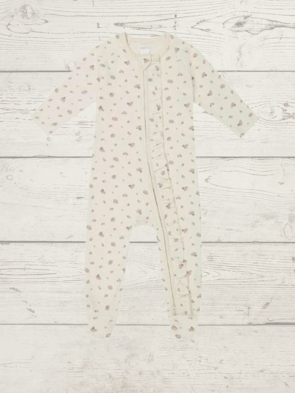 a baby onepiece with a floral design on it on a wooden background