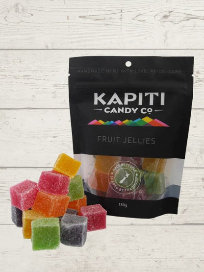 colourfull candy squares with packaging with Kapit Candy co on it on a wooden surface