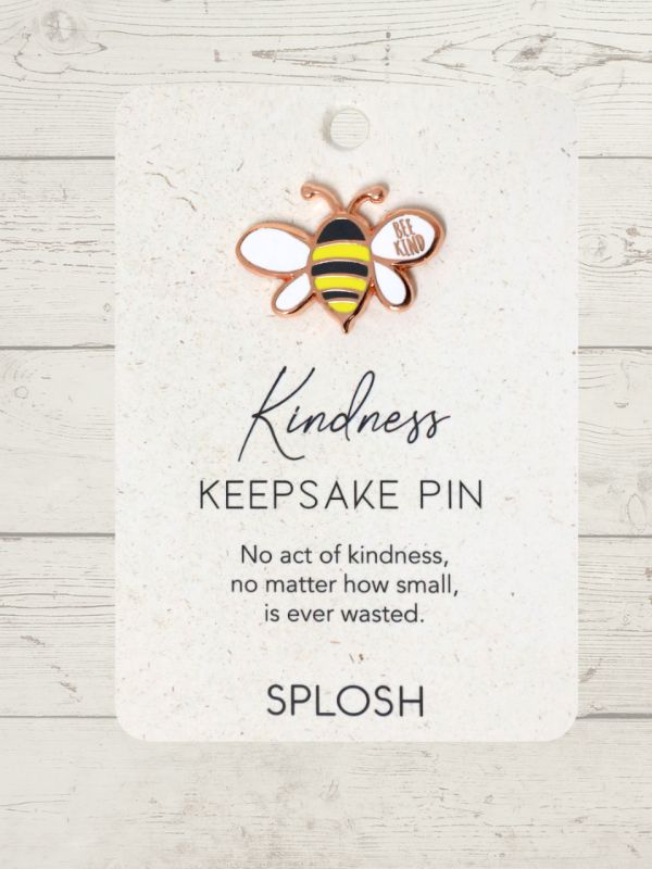 rose gold trimmed bee with the words Be Kind written in on of the wings on a card saying Kindness on a wooden background