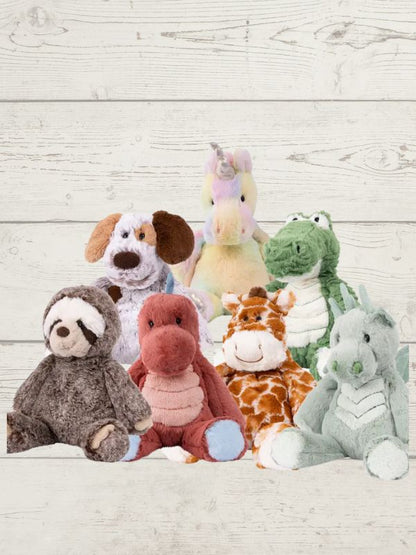 a collection of soft toys displayed on a white wooden background