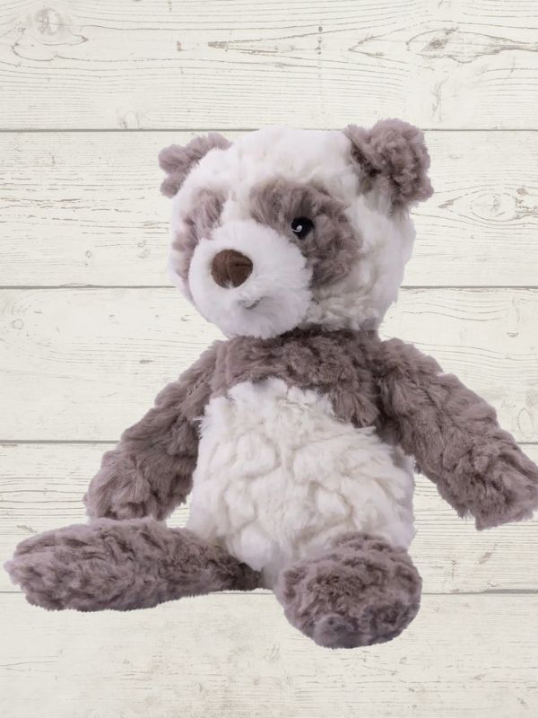 A plush toy resembling a panda with black and white fur, featuring embroidered eyes and a soft texture.