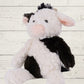 A plush toy resembling a cow with black and white fur, featuring embroidered eyes and a soft texture.