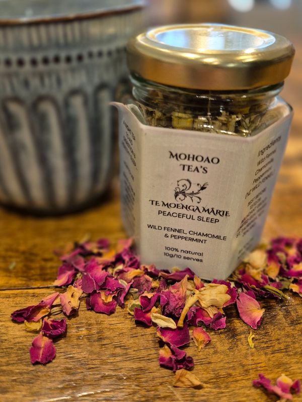 Jar of Mohoao Tea's Te MoengaMarie Peaceful Sleep blend with dried petals on a wooden surface