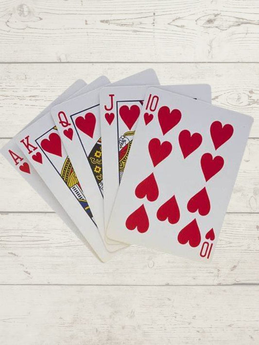 a spread of playing cards, ace, king, queen, jack and ten, all hearts on a wooden background