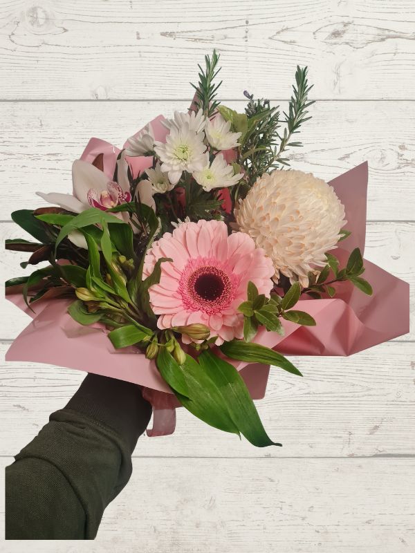 posy box of flowers with pink and white flowers on a light wooden background