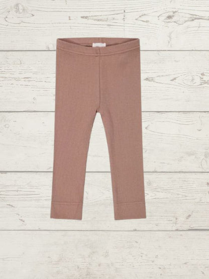 a pair of childrens leggings on a wooden surface