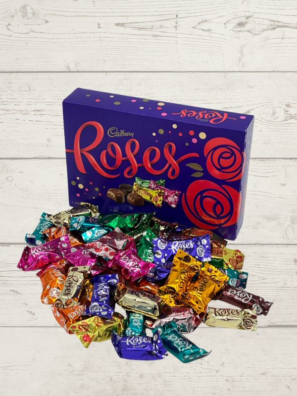 lots of colourful wrapped chocolates with packaging with the words Roses Chocolate on it on a wooden background
